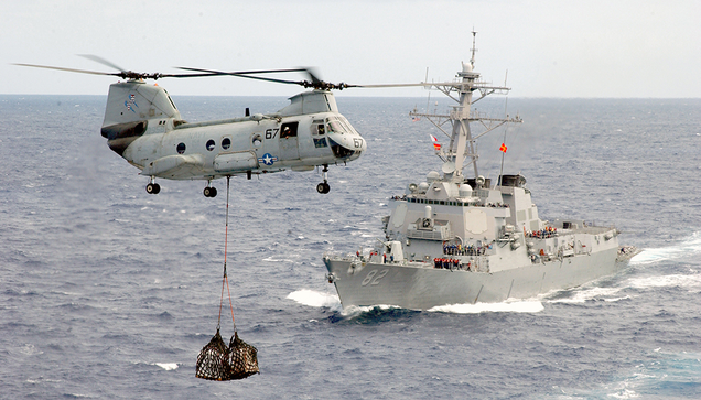 A CH-46D Sea Knight assigned to the “Gunbearers” of Helicopter Combat Support Squadron One One (HC-11) conducts a vertical replenishment while the guided missile destroyer USS Lassen (DDG 82) prepares to come alongside the fast combat support ship USS Sacramento (AOE 1) for an underway replenishment. (US Navy)